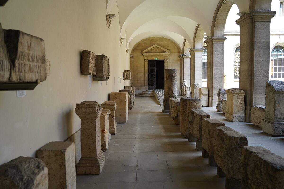 The arcaded courtyard of the Museum of Art and History, with carved Roman stone fragments lining the walls