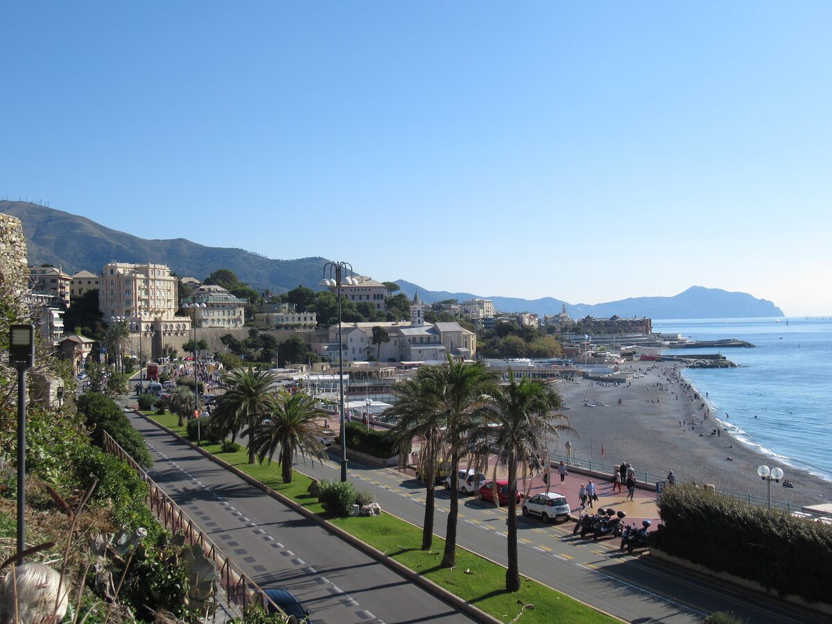 The palm-lined Corso Italia seafront road beside a pebble beach
