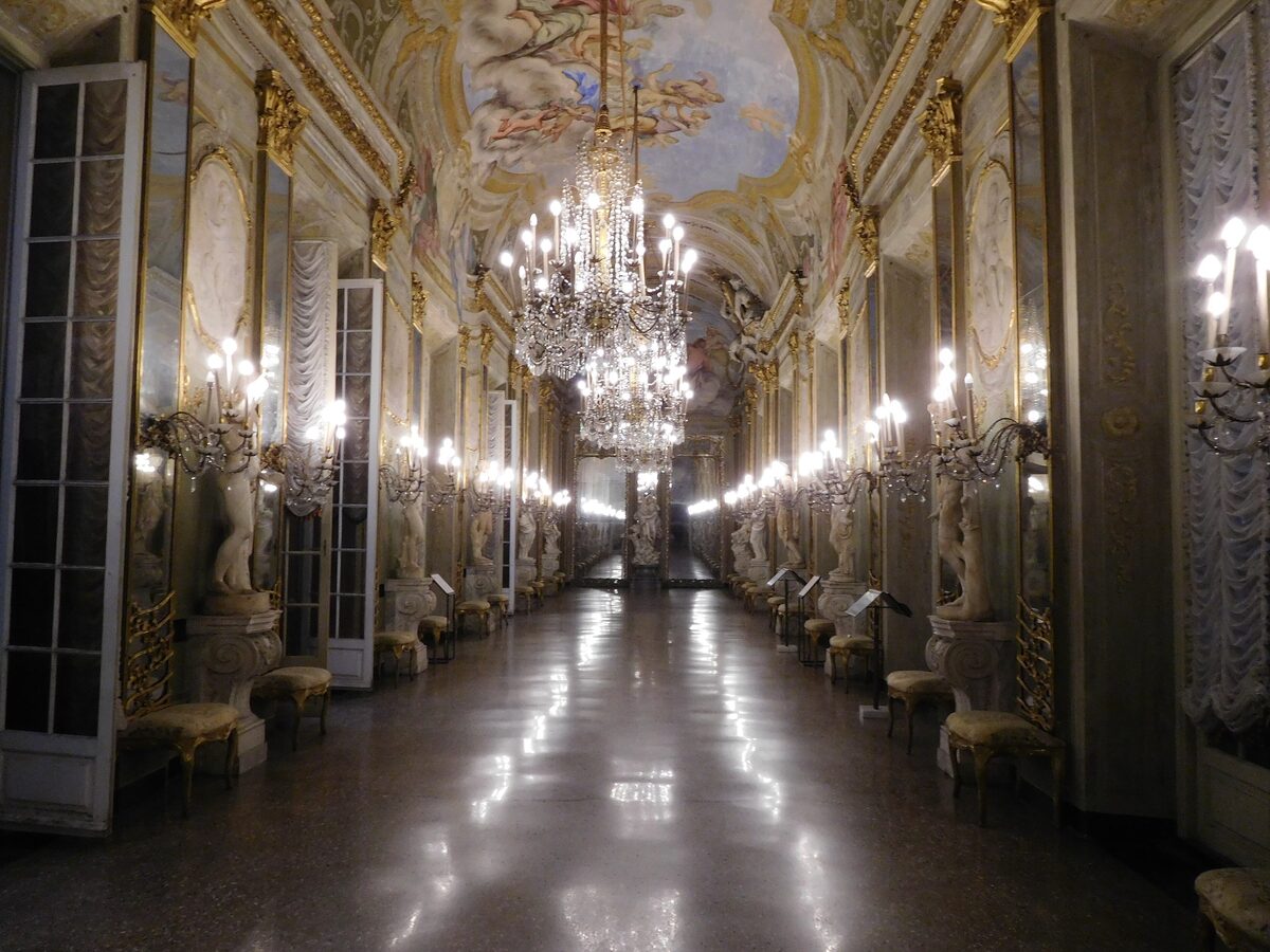 The Hall of Mirrors of Palazzo Reale with a chandelier and a painted ceiling