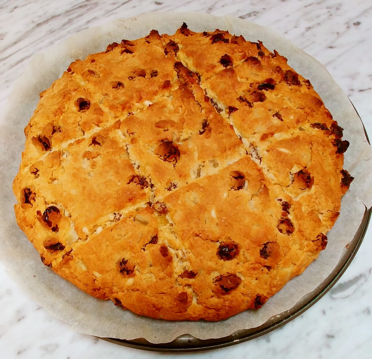 A round, scored pandolce studded with raisins and candied fruit
