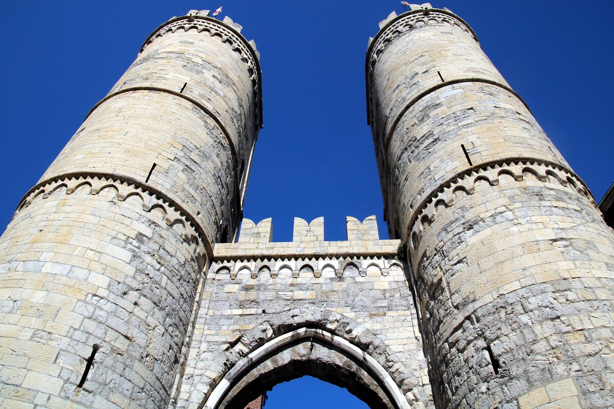 The two round towers of Porta Soprana, the medieval city gate, against a blue sky