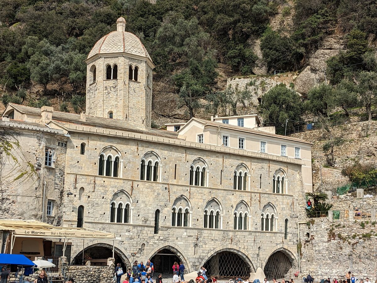 The stone abbey of San Fruttuoso with its domed bell tower in a wooded cove