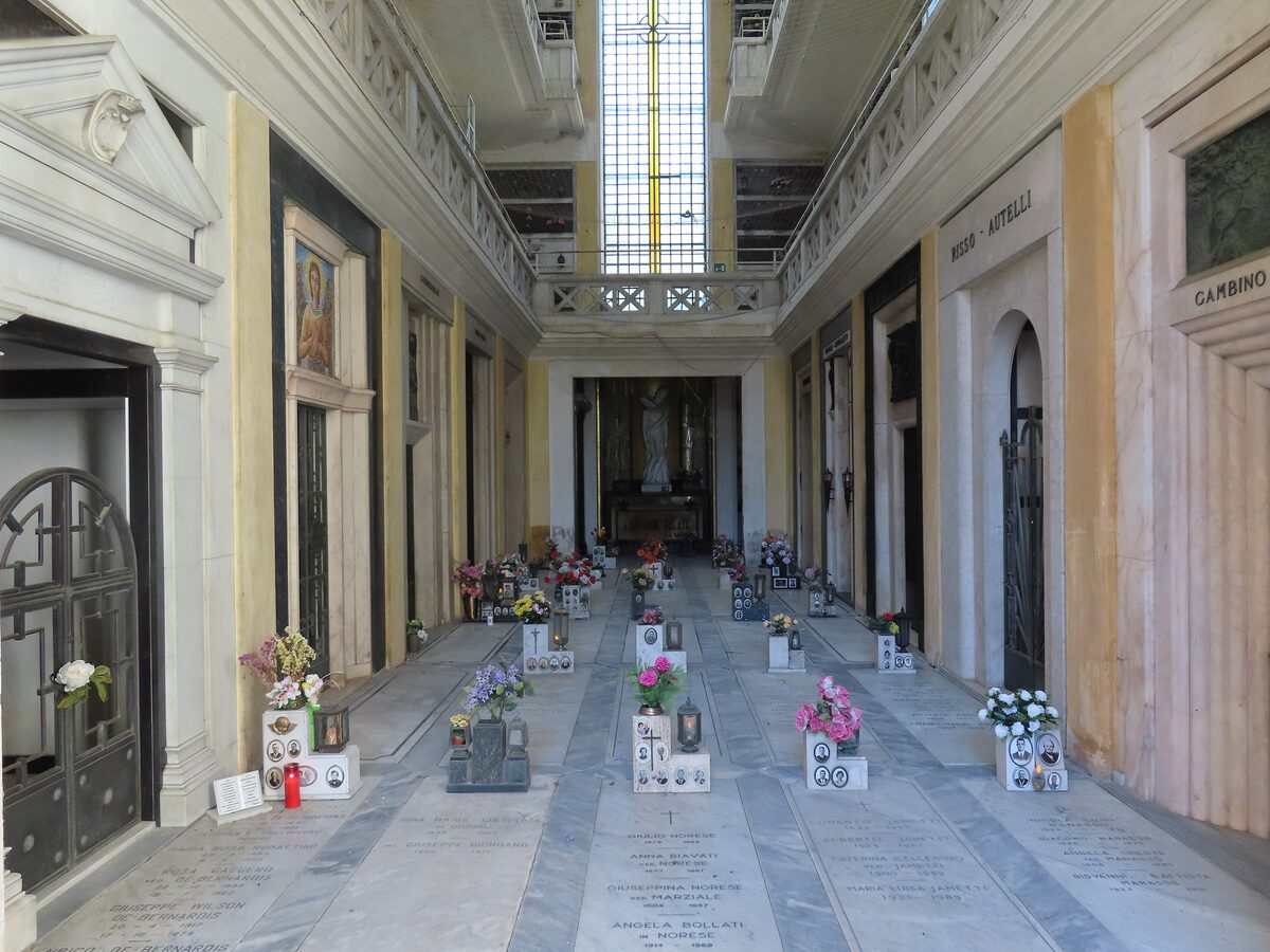 A marble arcade of tombs with fresh flowers at Staglieno Cemetery