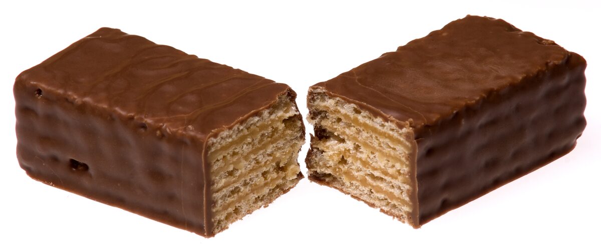 A Tunnock's Caramel Wafer bar broken in two, showing its wafer and caramel layers inside the chocolate