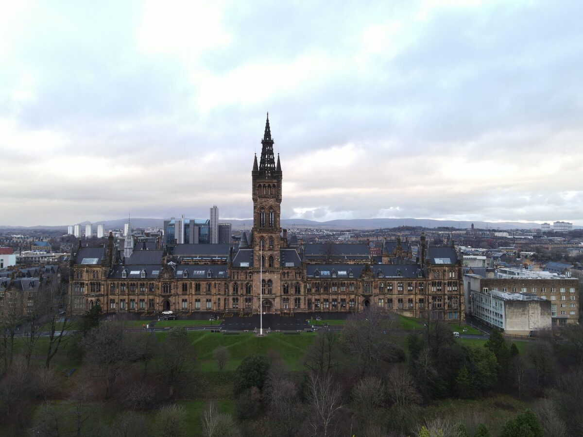 The University of Glasgow's Gothic main building with its tall tower above the trees of Kelvingrove Park