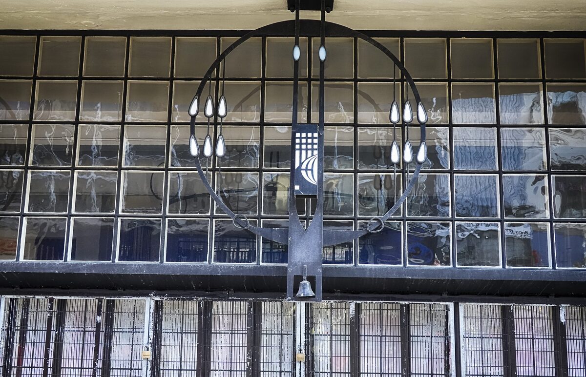 Mackintosh's leaded glass windows with a curved black iron frame and hanging lamps on the front of the Willow Tearooms