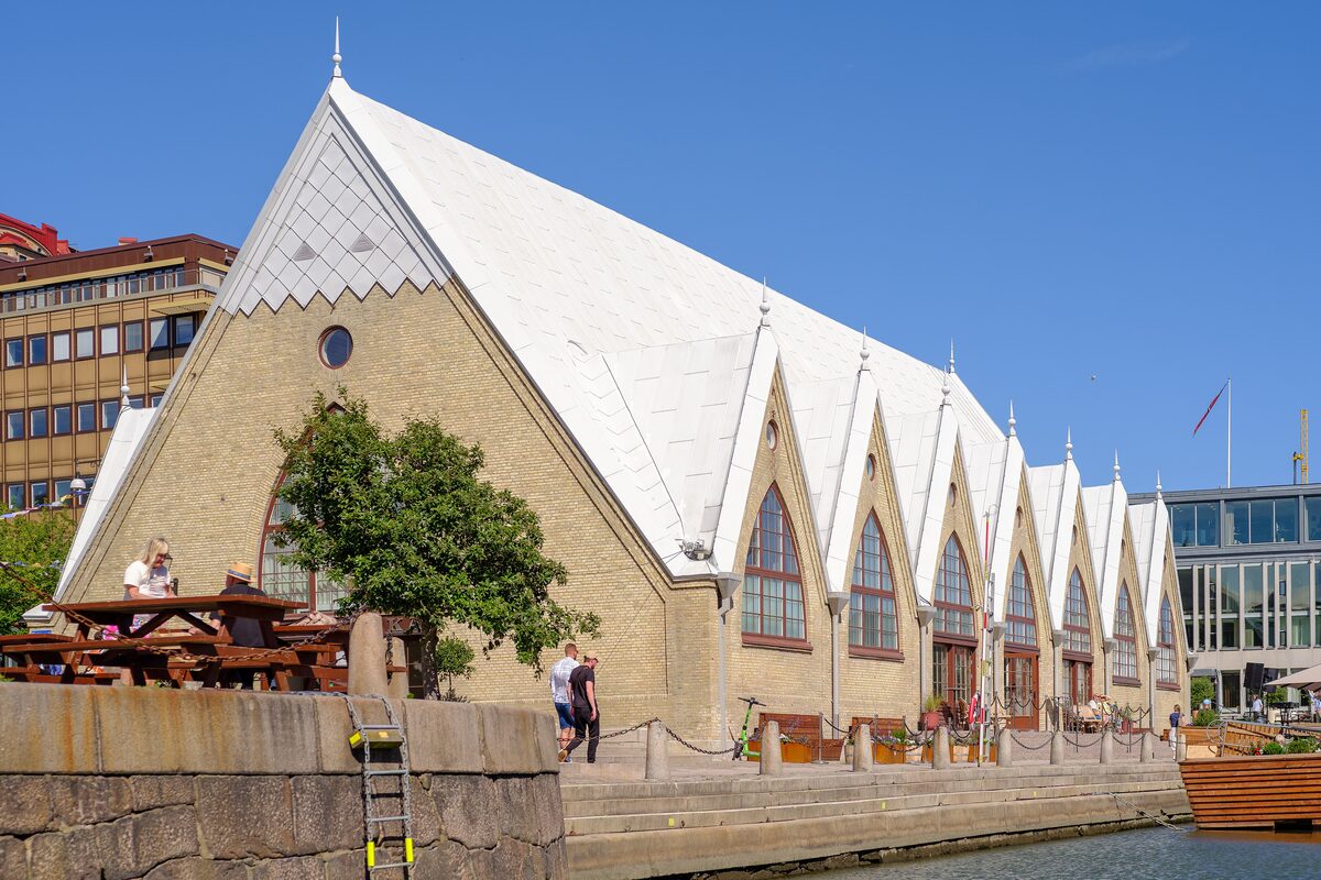 The yellow brick Feskekôrka fish market hall with its steep Gothic roof by the canal