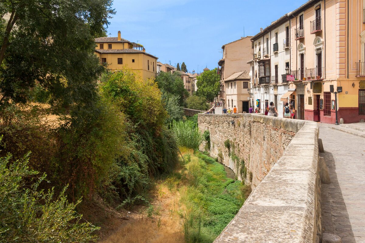 Carrera del Darro in Granada, a cobbled street running beside the little river Darro, with old houses and stone bridges