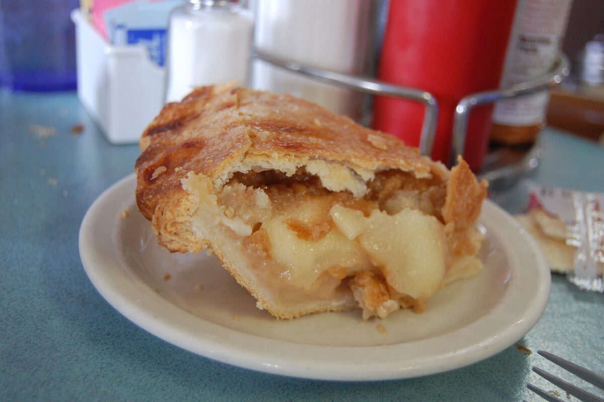 A slice of apple pie on a diner plate
