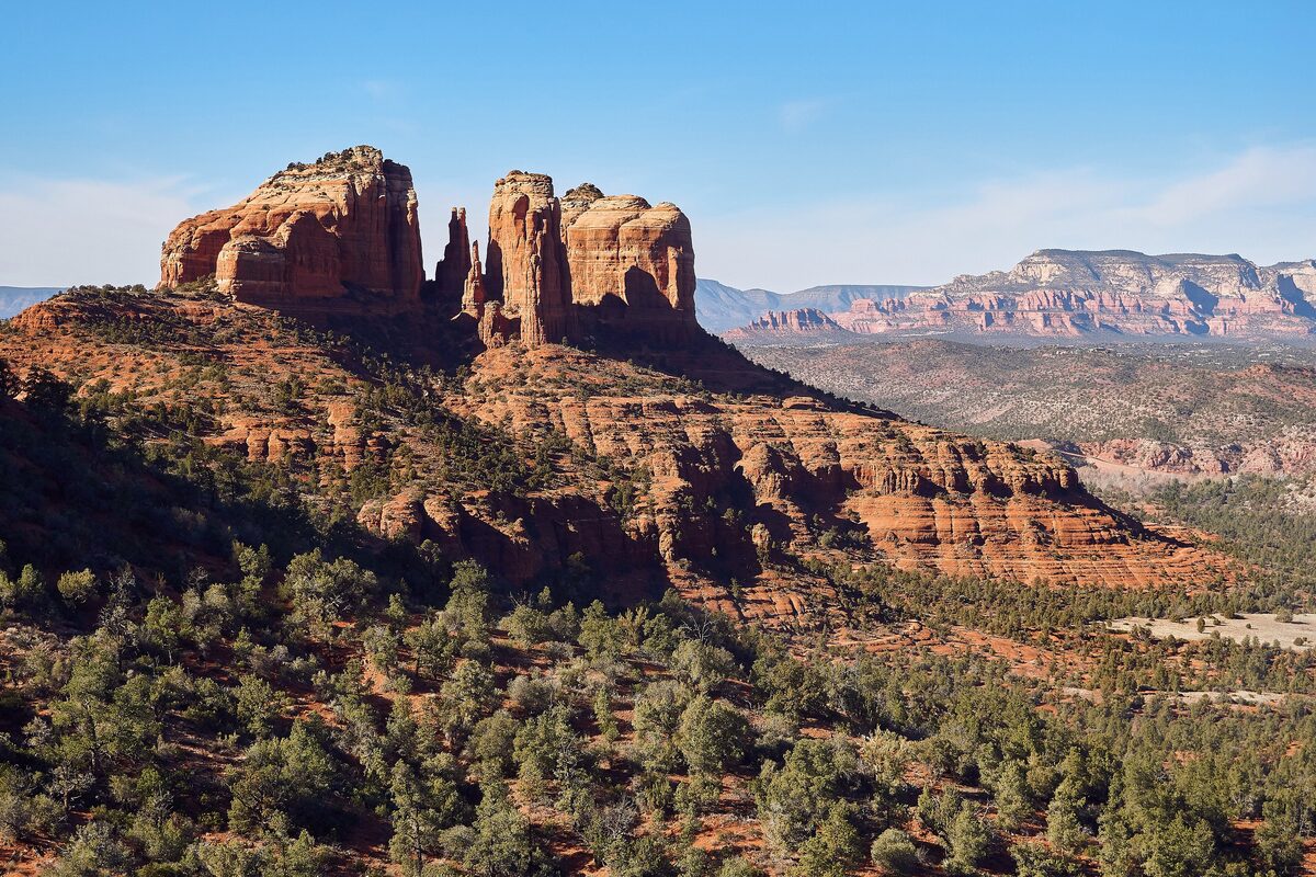 Cathedral Rock's twin red towers above juniper hills, seen from the loop trail