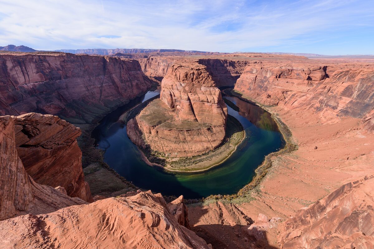 The Colorado River curling around Horseshoe Bend in deep red cliffs