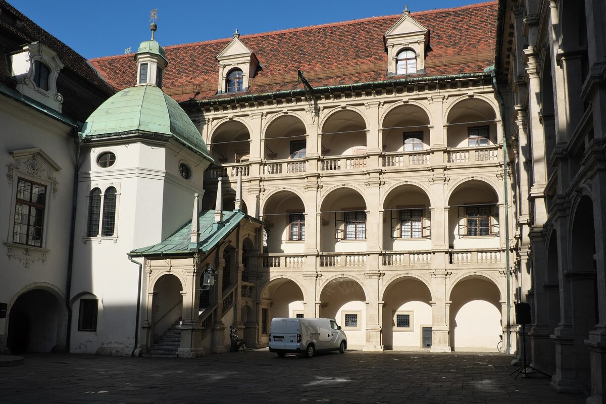 The three-story arcaded Renaissance courtyard of the Landhaus in Graz, with a green-domed chapel
