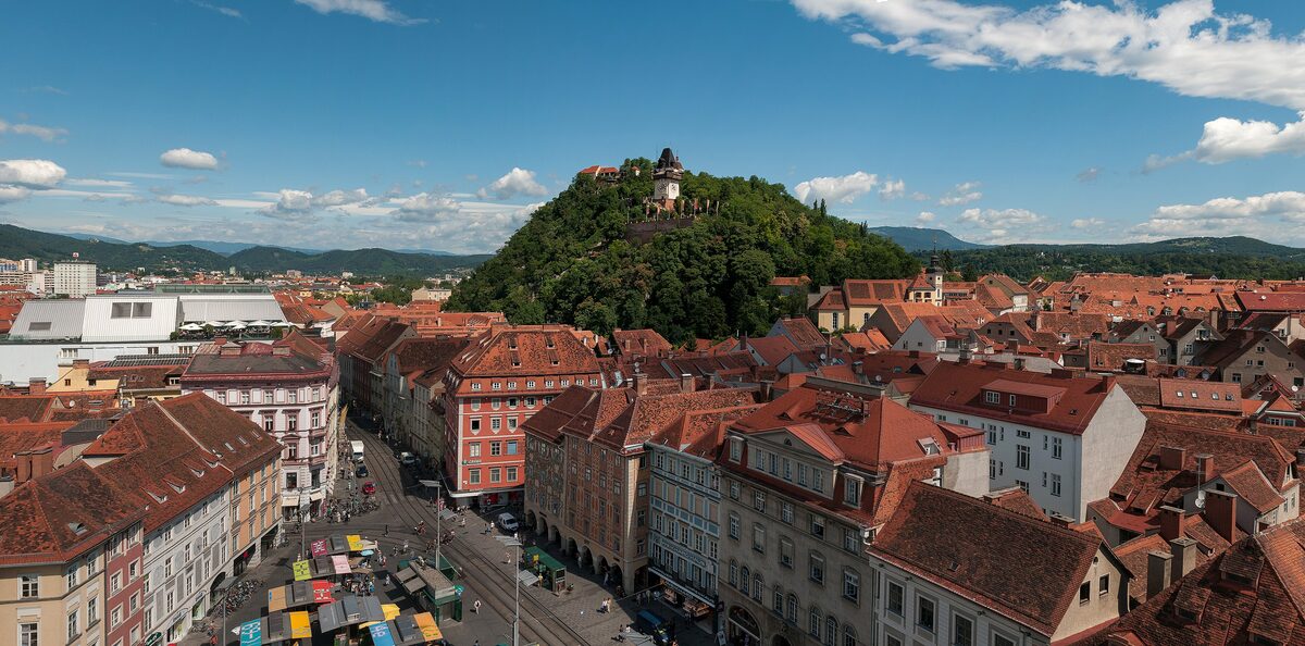 The red roofs of Graz's old town with the green Schlossberg rising behind them