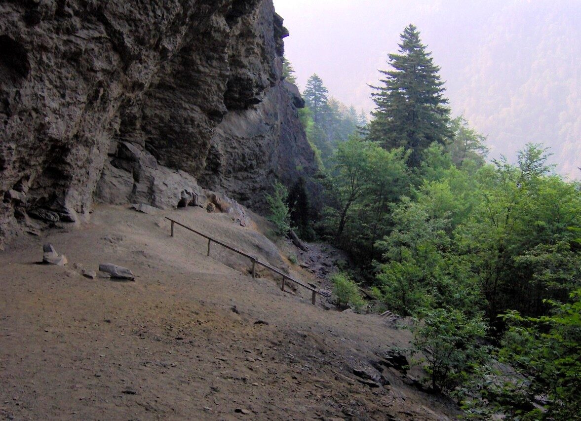 The overhanging rock of Alum Cave Bluffs above a dusty trail ledge