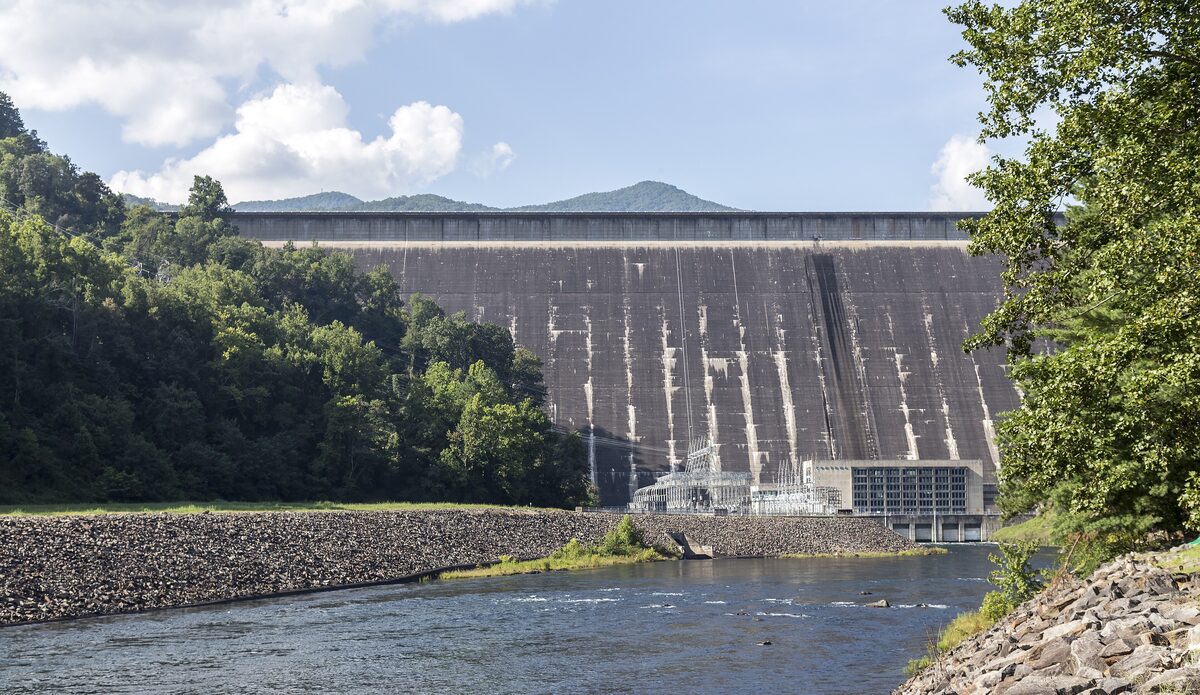 Fontana Dam rising above the river with wooded mountains on both sides