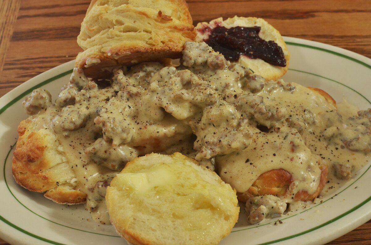 Split biscuits covered in peppery sausage gravy on a plate
