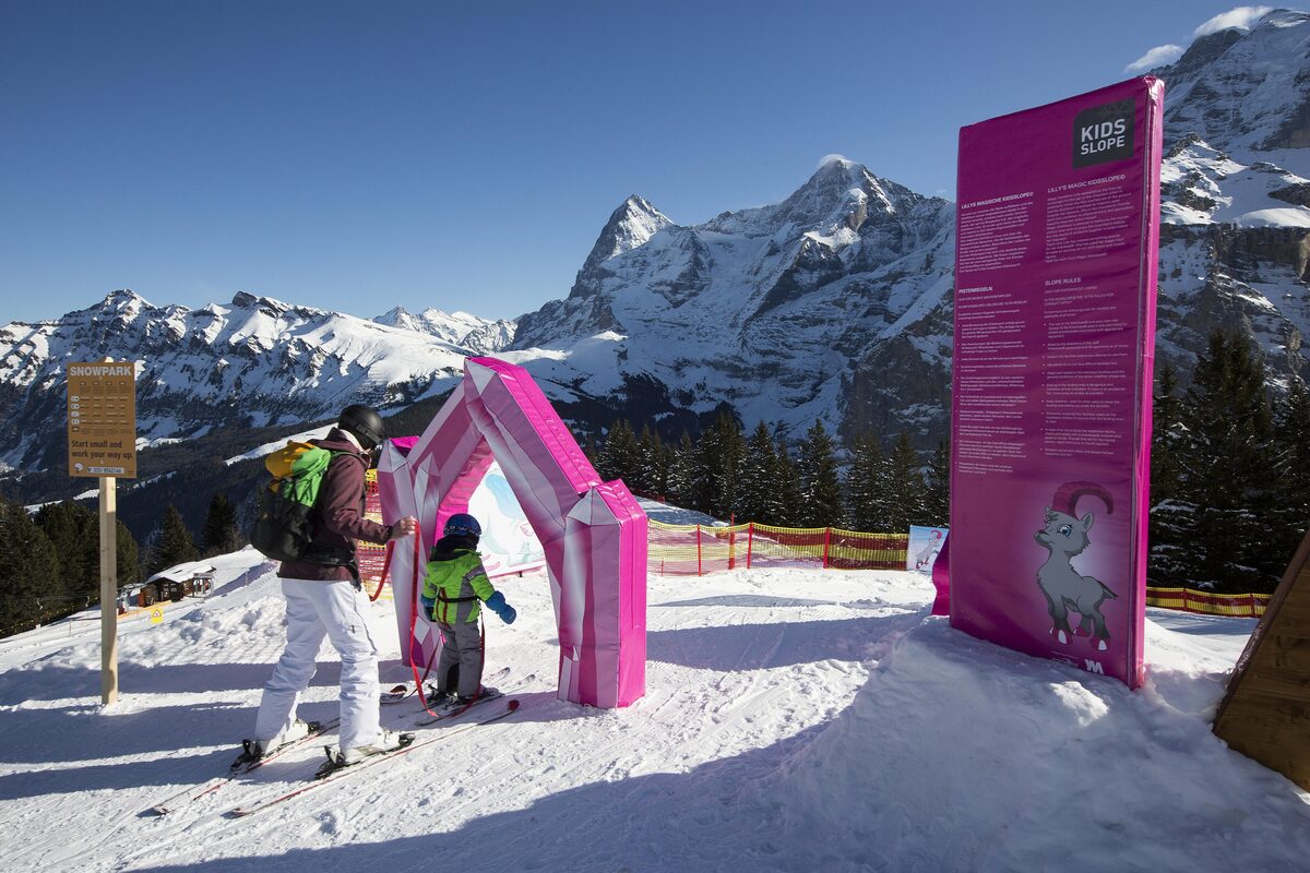 A skier and a child at the kids' slope on the Allmendhubel above Mürren