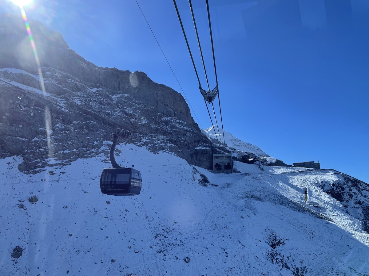An Eiger Express gondola cabin on its cable beside the snowy Eiger