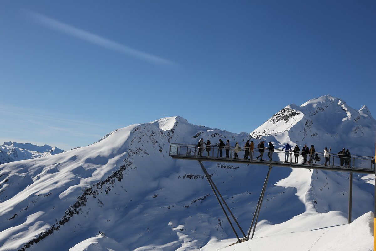 Visitors on the steel Cliff Walk above the snowy slopes of First