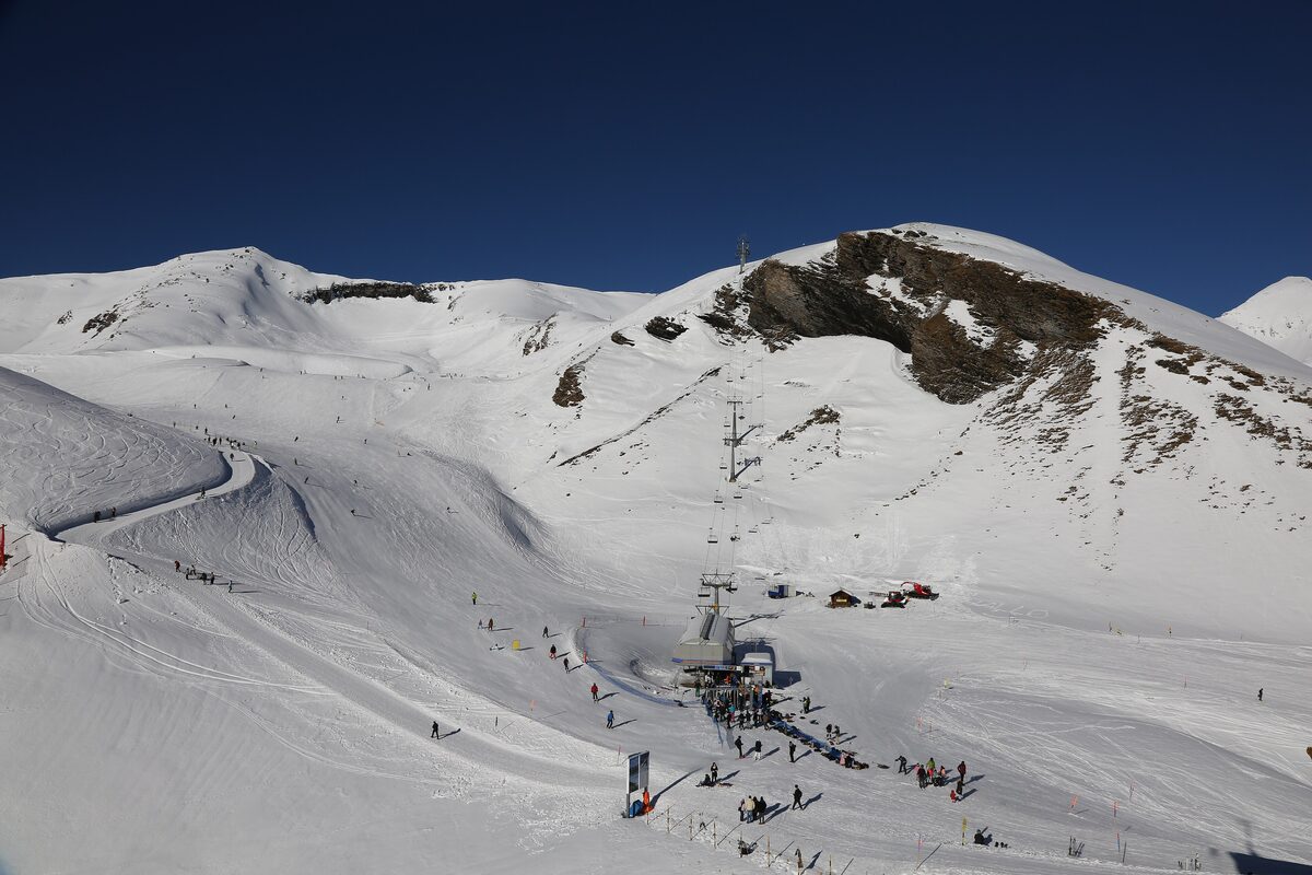 Skiers on the groomed slopes of Grindelwald First with a chairlift