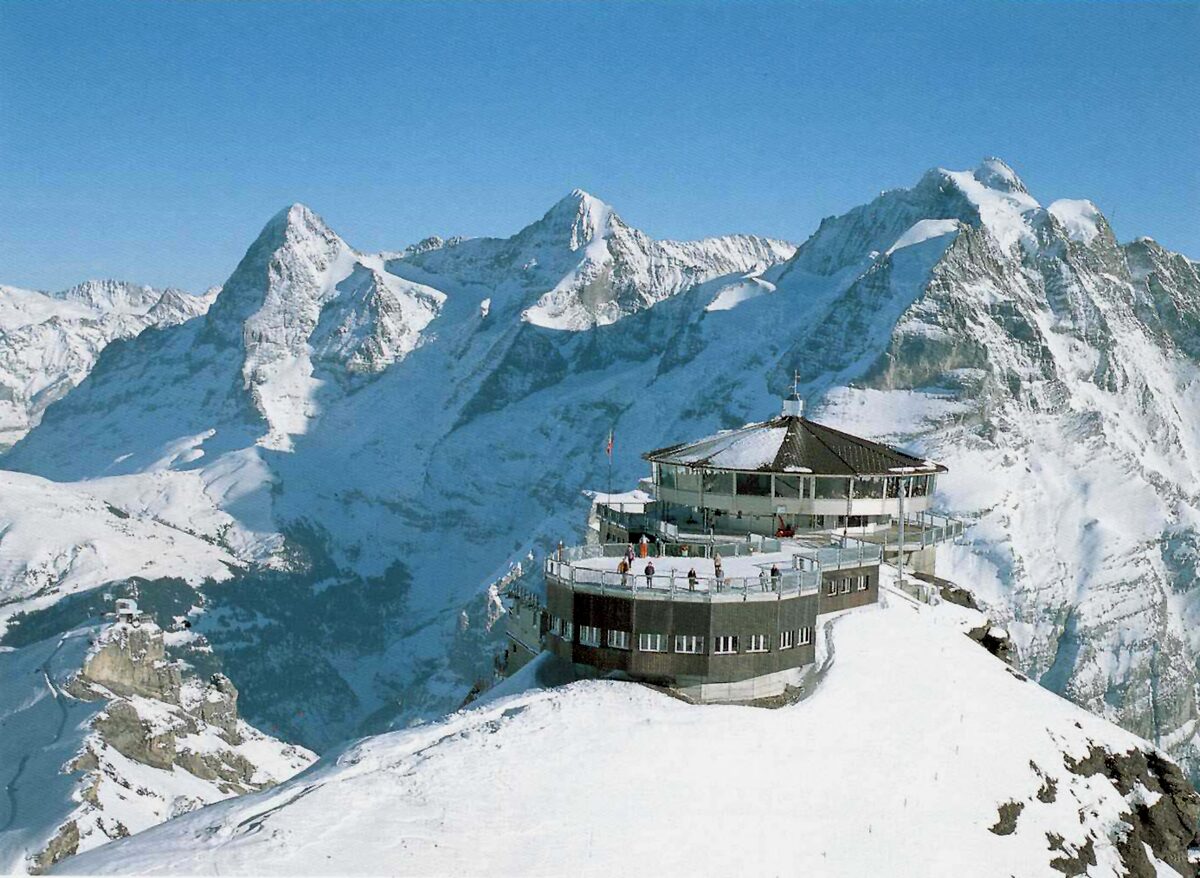 The round Piz Gloria restaurant on the snowy Schilthorn summit with the Eiger, Mönch and Jungfrau behind