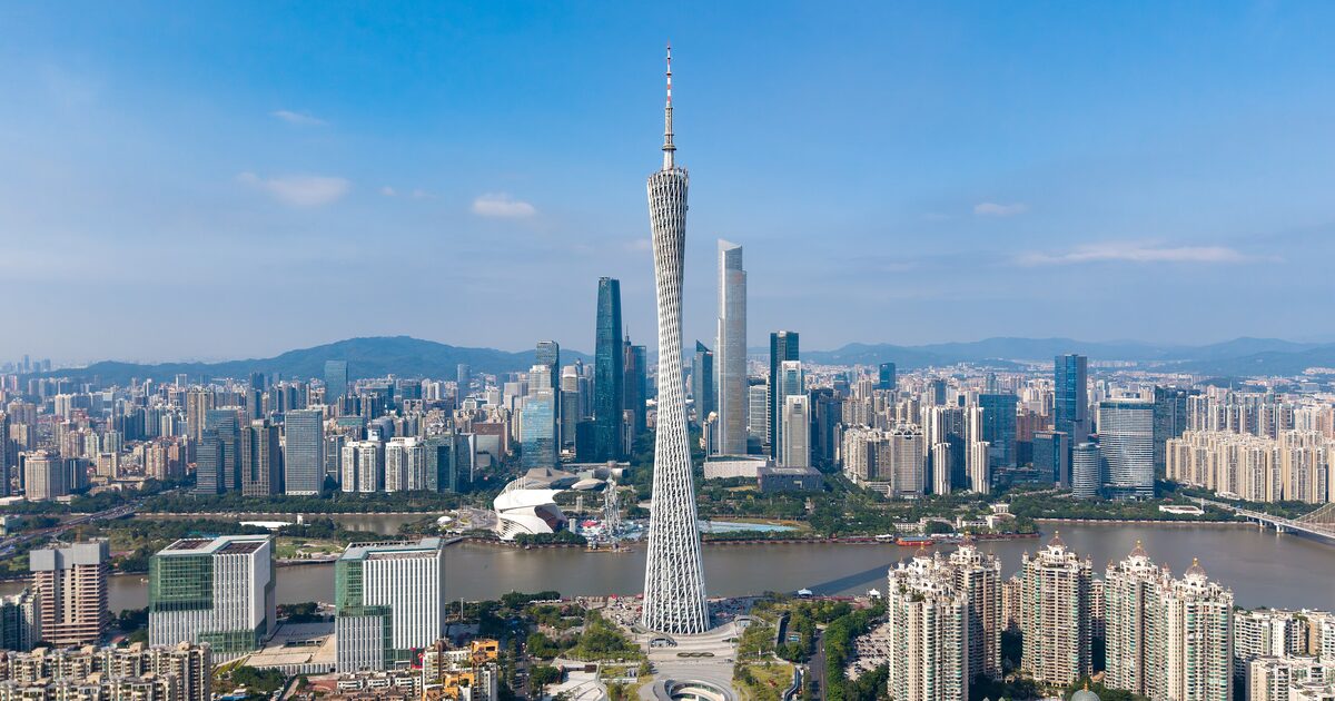 Aerial view of Canton Tower on the bank of the Pearl River with the Zhujiang New Town skyline under a blue sky