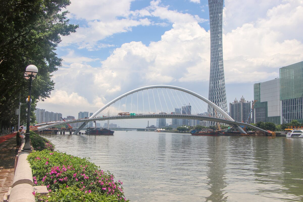 The white arch of Haixin Bridge over the Pearl River with Canton Tower rising behind it