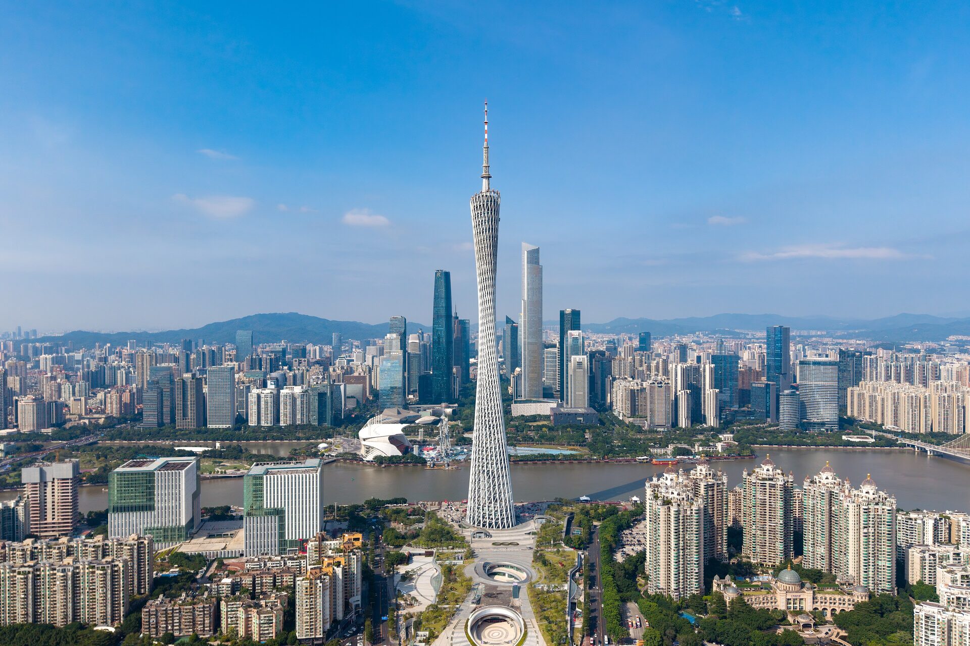 Aerial view of Canton Tower on the bank of the Pearl River with the Zhujiang New Town skyline under a blue sky