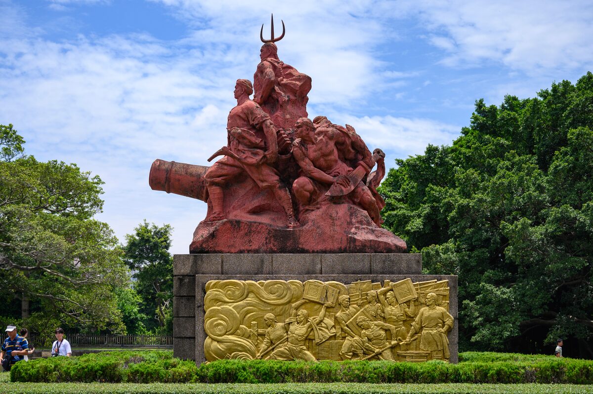 The red sculpture group with a cannon and gilded relief at the Opium War Museum in Humen