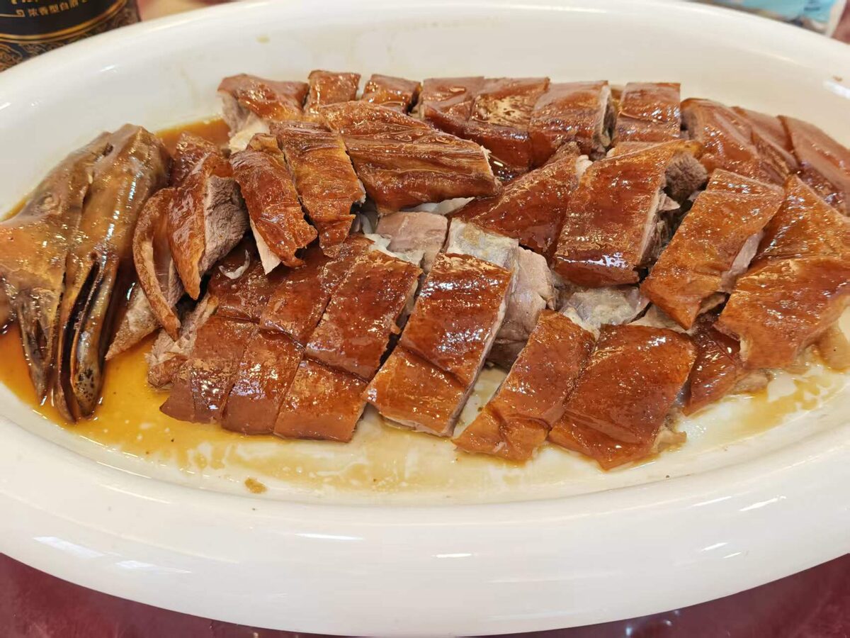 A platter of chopped Cantonese roast goose with glossy brown skin, served in Guangzhou