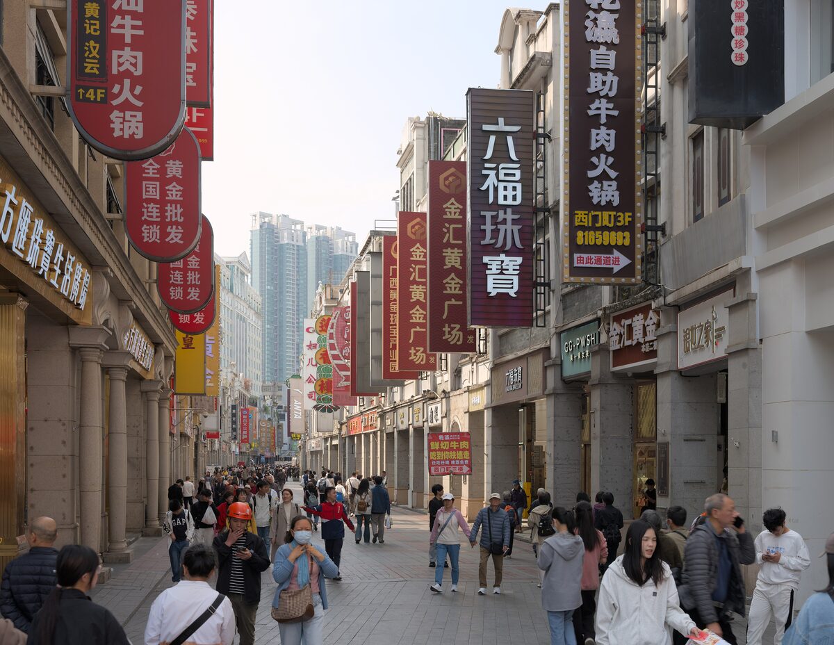 Shoppers on the pedestrian street of Shangxiajiu, lined with red shop signs and old arcaded buildings
