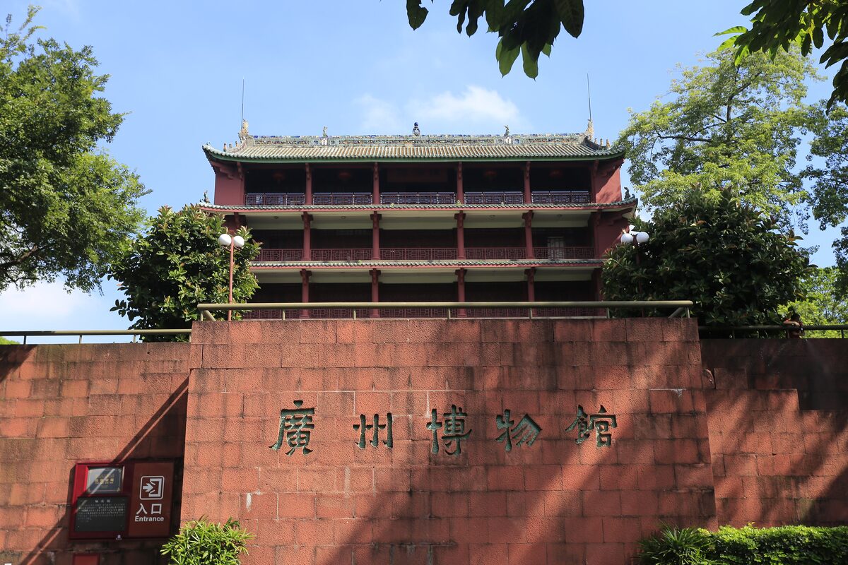 Zhenhai Tower, the five-story red tower, rising above the red sandstone wall marked Guangzhou Museum