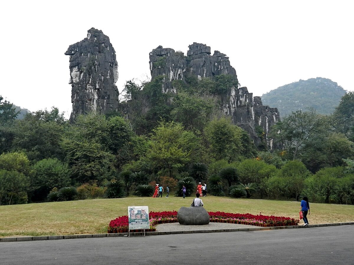 Camel Rock in Seven Star Park, a pair of craggy limestone pinnacles above a lawn with red flower beds