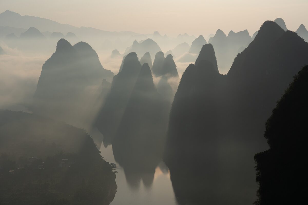 Rows of misty karst peaks along the Li River in the soft light of sunrise seen from Xianggong Hill