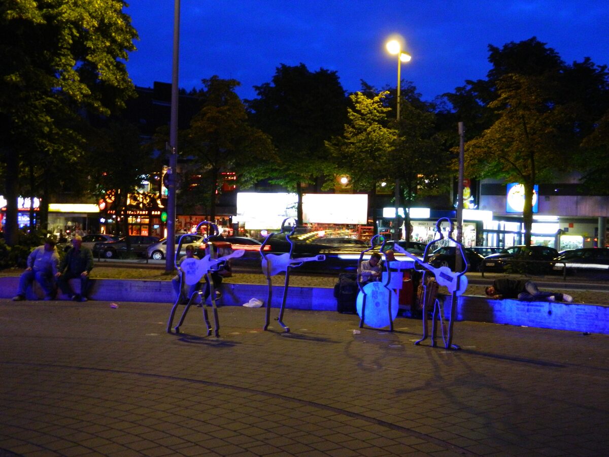 Steel figures of the Beatles lit in blue at the Beatles-Platz at night