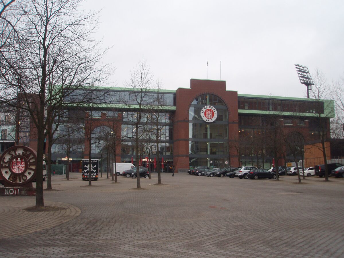 The main stand of the Millerntor-Stadion with the club crest above its entrance and bare trees on the forecourt