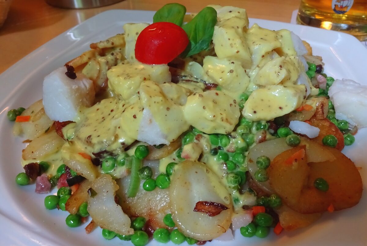 Pannfisch, pieces of fish in mustard sauce over fried potatoes and peas