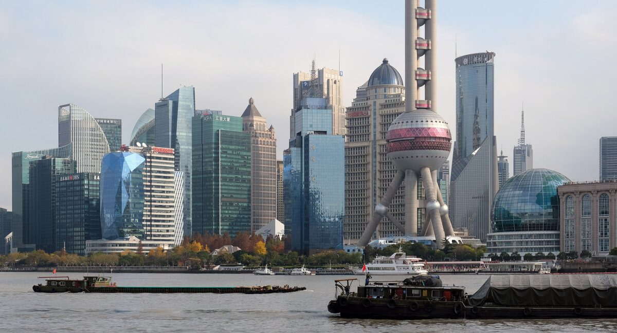 The Pudong skyline with the Oriental Pearl Tower seen across the Huangpu River, with cargo barges on the water