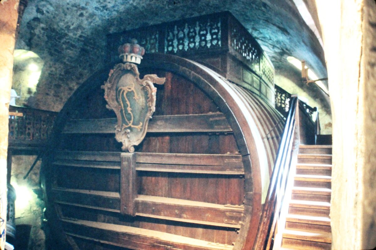 The Great Tun in the castle cellar, a huge wooden wine barrel with a carved coat of arms and a staircase beside it