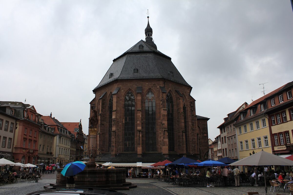 The Church of the Holy Spirit on the Marktplatz, with market stalls and umbrellas in front of its choir