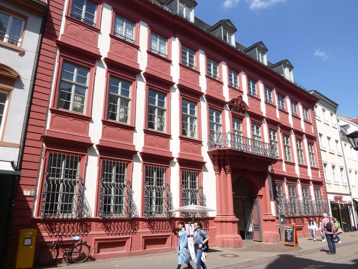 The red Baroque Palais Morass on the Hauptstraße, home of the Kurpfälzisches Museum, with a balcony and barred ground-floor windows