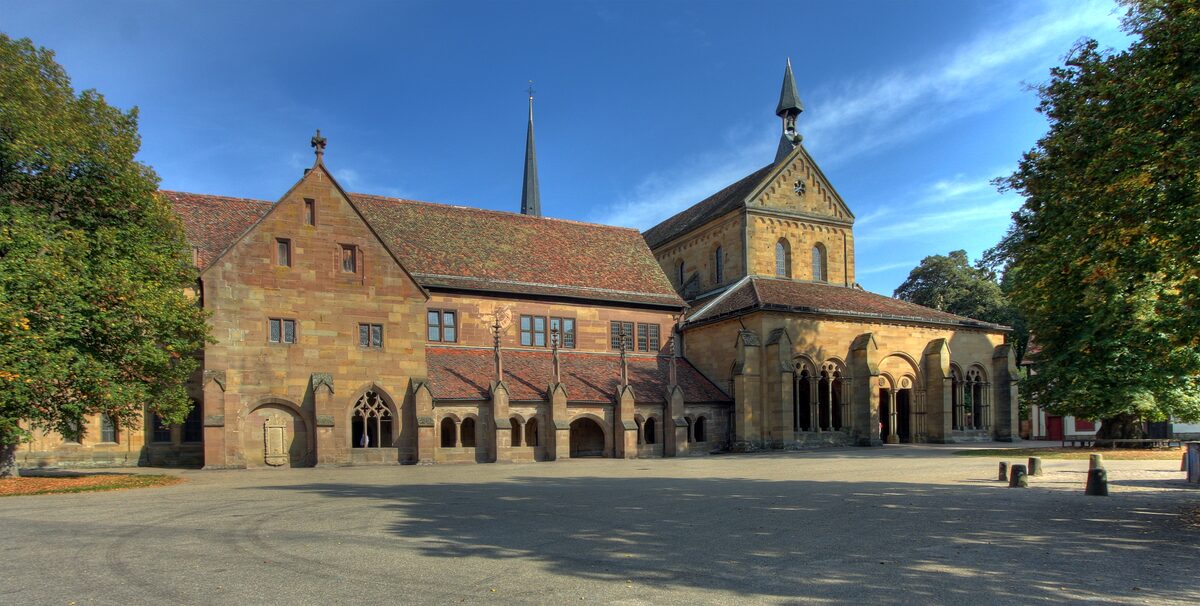 The stone buildings and church of Maulbronn Monastery around a sunlit courtyard