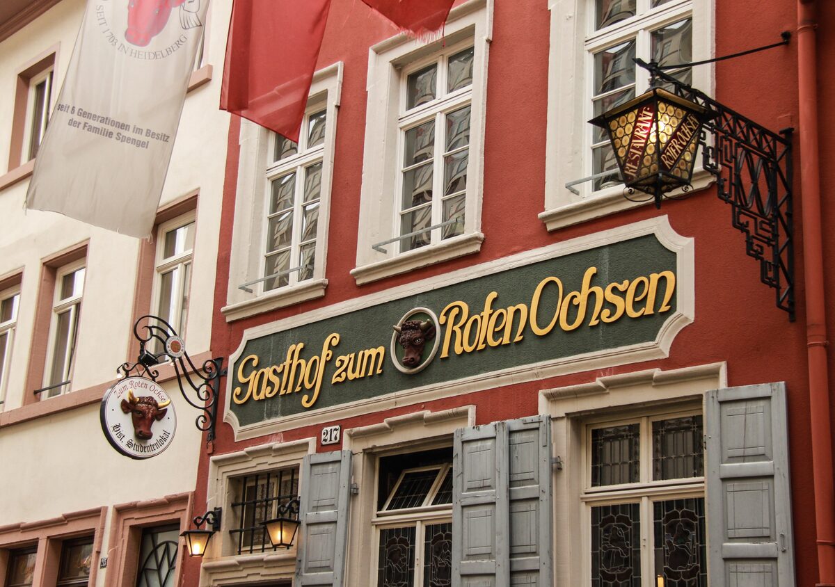 The red front of the Gasthof Zum Roten Ochsen on the Hauptstraße, with its green sign and the bull's-head hanging sign