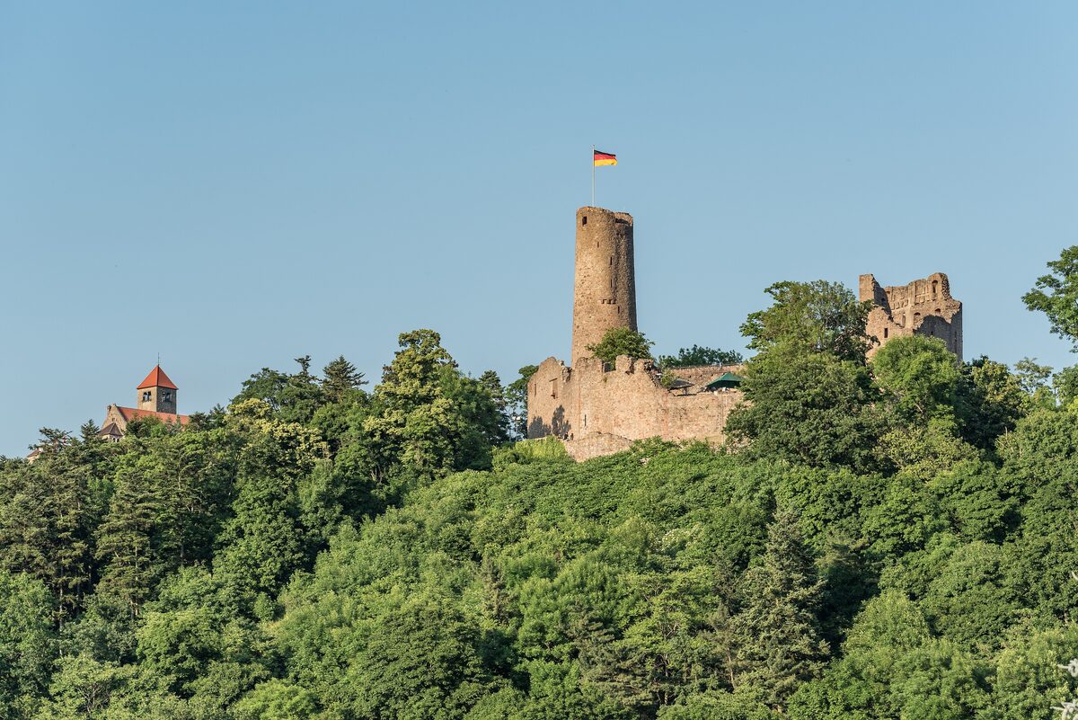 The Windeck castle ruin and its round keep on a wooded hill above Weinheim, with the Wachenburg on the left