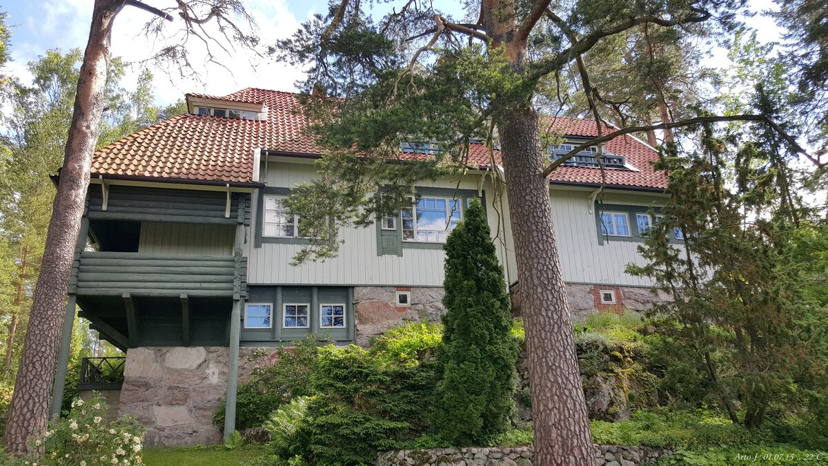 Ainola, the wooden villa of Jean Sibelius, with a balcony, among tall pines