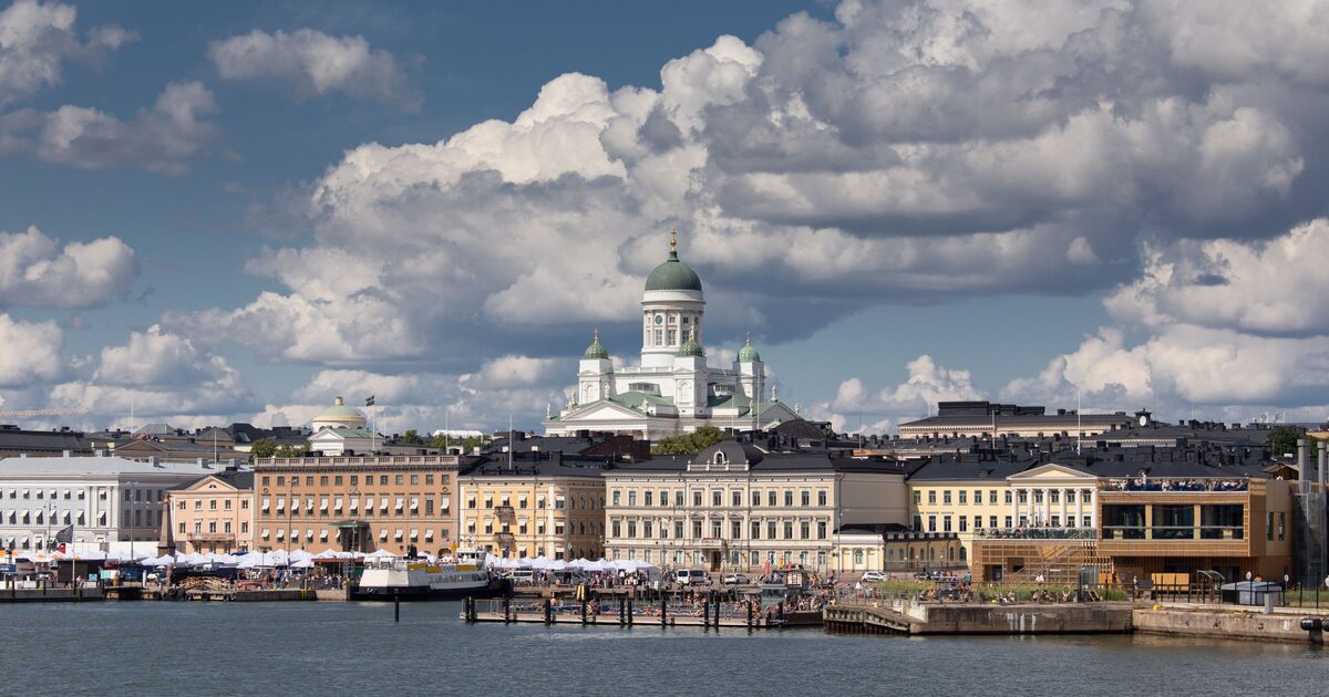 Helsinki's waterfront seen from the sea, with the white Helsinki Cathedral and its green dome rising above a row of pale buildings