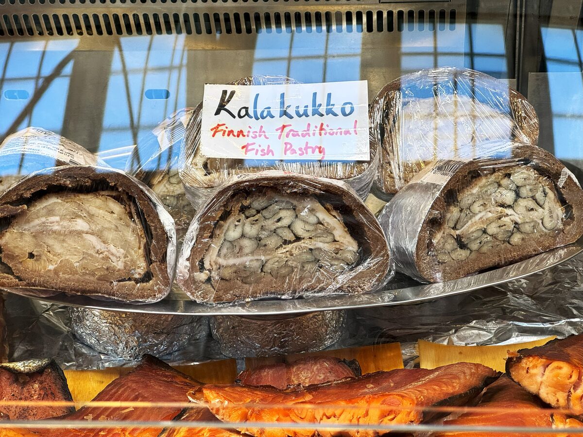 Kalakukko fish pies wrapped in rye crusts on display under a sign at the Old Market Hall in Helsinki