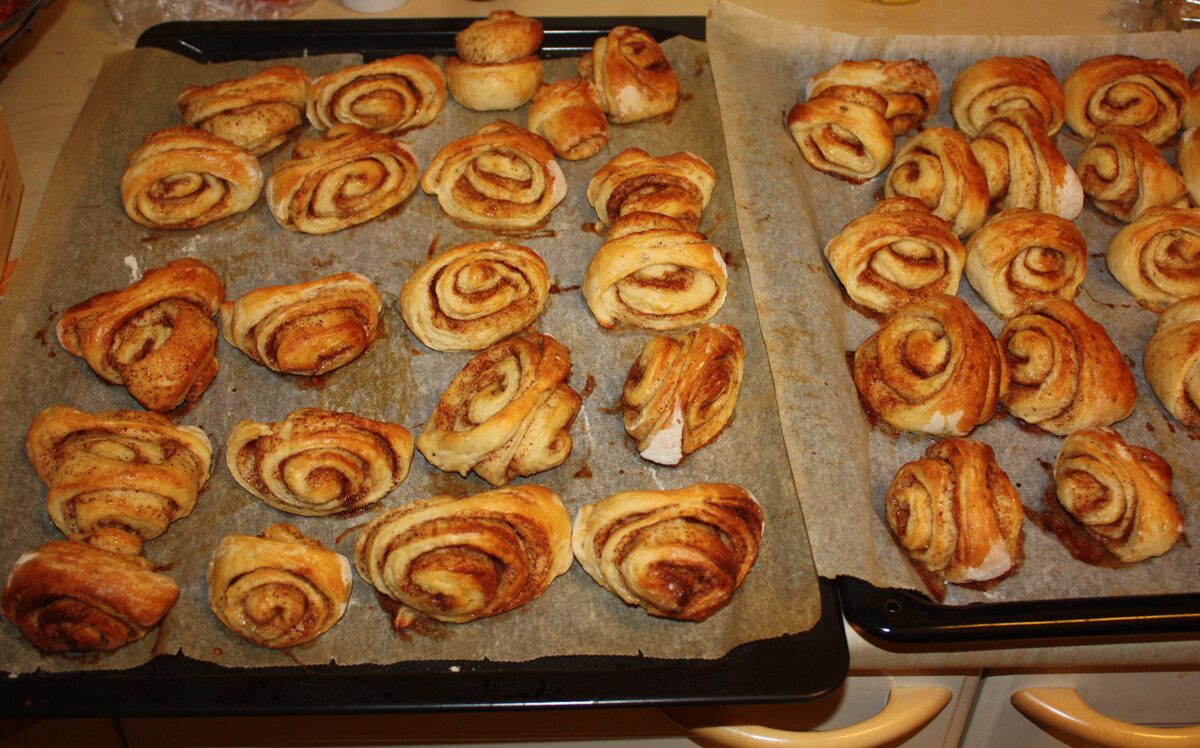 Two baking trays of freshly baked Finnish cinnamon buns with pearl sugar