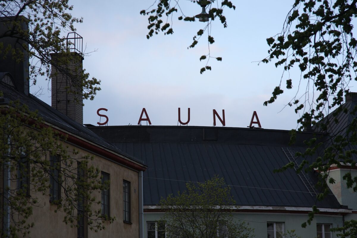 Large white letters spelling SAUNA on the roof of the Kotiharju public sauna building in Kallio