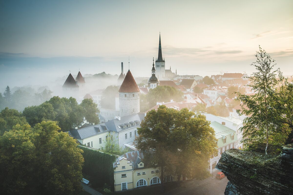 Tallinn's medieval old town at sunrise, with red roofs, church spires and the town walls
